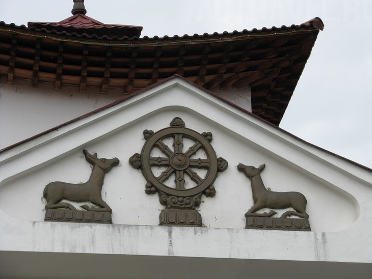 Над входом один из главных буддистских символов - колесо дхармы (дхармачакра)